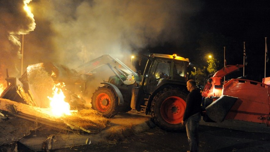 Un agriculteur près d'un incendie allumé par des éleveurs qui protestent contre les prix trop bas de la viande à Saint-Brieuc le 2 juillet 2015