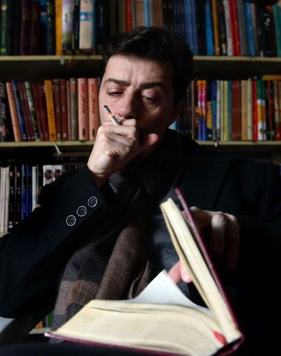 Julien Columeau fume une cigarette dans une librairie de Lahore au Pakistan, le 20 janvier 2014