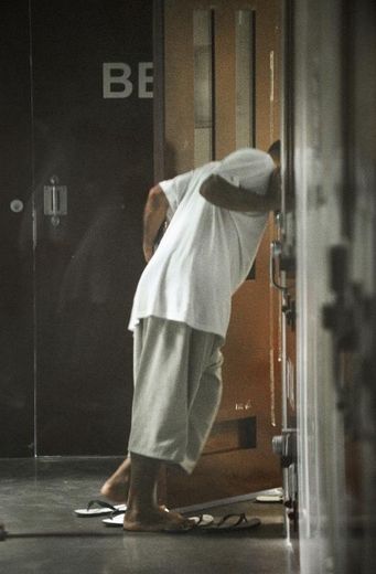 Un détenu de Guantanamo passe la tête à travers la cellule d'un autre prisonnier du camp 6, le 30 mars 2010