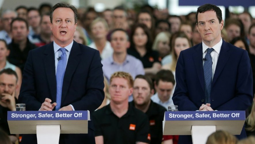 Le ministre des Finances britannique George Osborne (D) écoute le Premier ministre David Cameron à Chandler's Fort, dans le sud de l'Angleterre, le 23 mai 2016