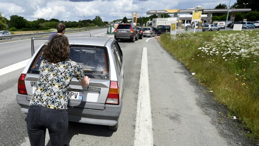 Des automobilistes poussent leur voiture vers une station-service, le 23 mai 2016 à Vern-sur-Seiche près de Rennes