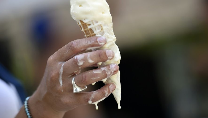 Une glace fond dans les mains de sa consommatrice à Paris le 2 juillet 2015