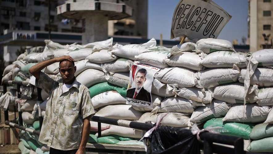 Un Egyptien pro-Morsi devant une barricade sur la place Rabaa al-Adawiya du Caire