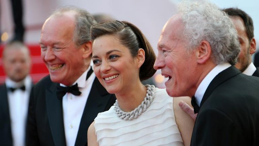Les réalisateurs belges Luc et Jean-Pierre Dardenne entourent l'actrice française Marion Cotillard lors de la projection du film "Deux jours, une nuit" au 67e festival de Cannes, le 20 mai 2014