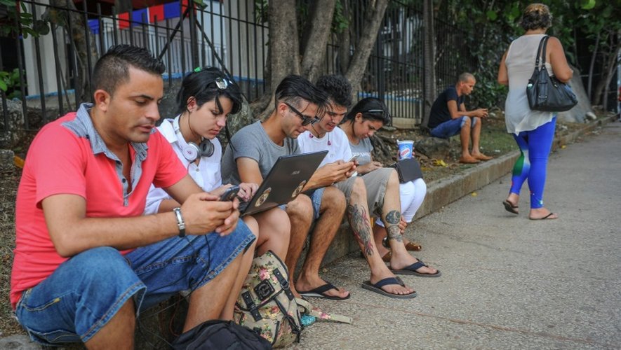 Des Cubains utilisent le wifi public sur leur téléphone dans une rue de La Havane le 2 juillet 2015