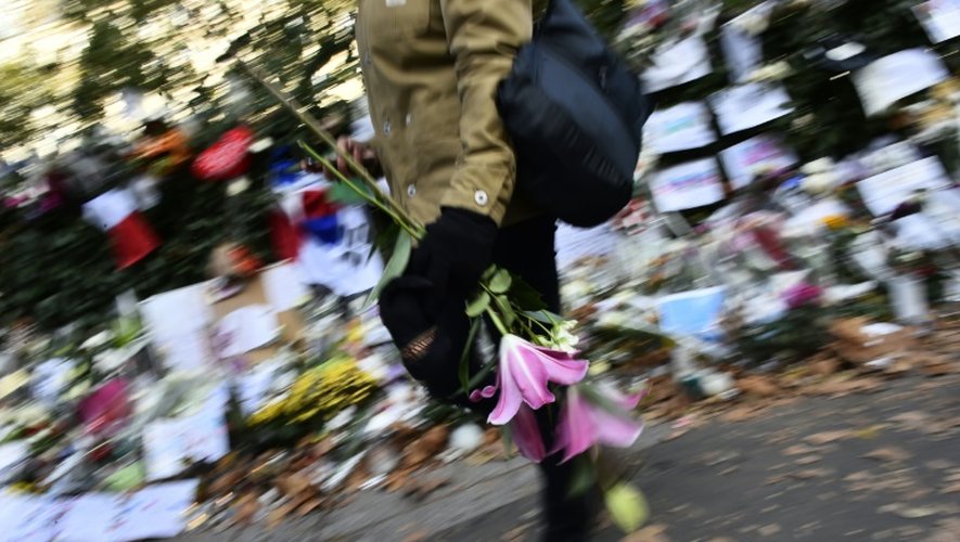 Une femme apporte des fleurs en hommage aux victimes du Bataclan le 22 novembre 2016 à Paris
