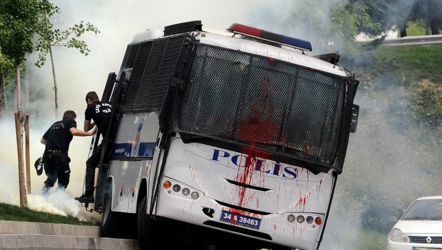 Des policiers anti-émeutes sautent de leur bus qui vient d'être attaqué par des manifestants le 23 mai 2014 à Istanbul