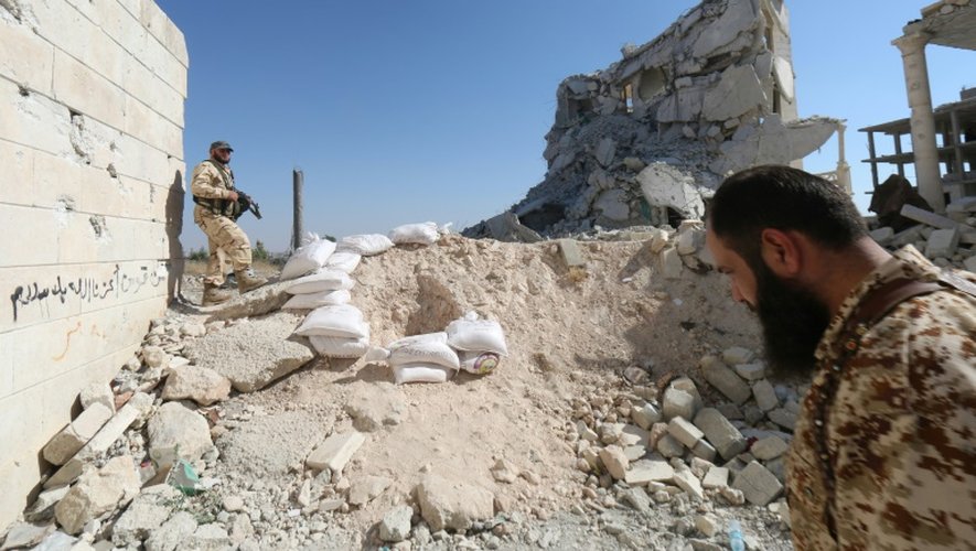 Des rebelles parmi les décombres de bâtiments détruits dans un ancien centre de recherches scientifiques, transformé en une caserne par le régime, dont ils ont pris le contrôle le 4 juillet 2015 à Alep
