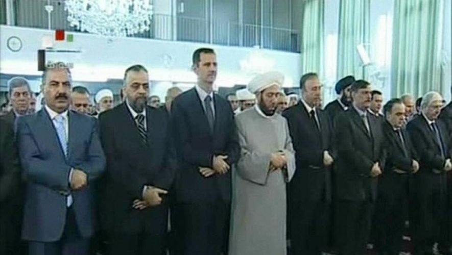 Capture d'écran d'images de la télévision syrienne montrant le président Bashar al-Assad (3è g) et le grand Mufti Ahmed Hassun (C) le 8 août 2013 dans une mosquée de Damas