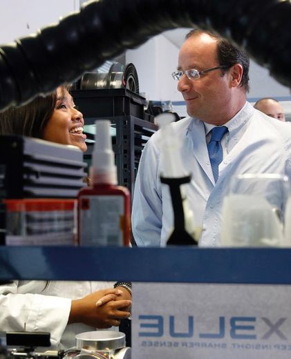 Le président François Hollande (d) écoute une employée de la société iXBlue, le 8 août 2013 à Marly-le-Roi (Yvelines)