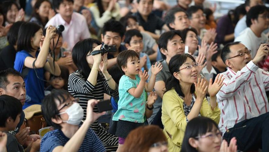 Le public applaudit au lancement de la fusée  H-2A retransmis le 24 mai 2014 sur écran géant à Tokyo