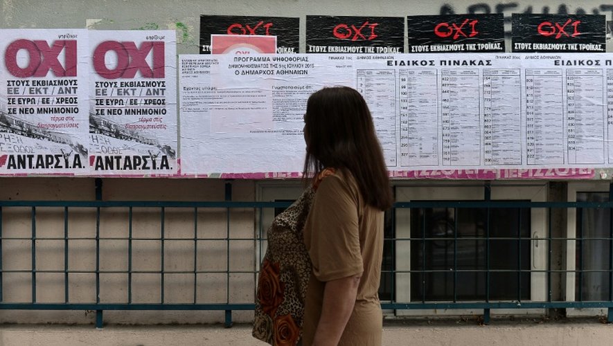 Une femme devant les affiches électorales dans un bureau de vote d'Athènes, jour du référendum le 5 juillet 2015