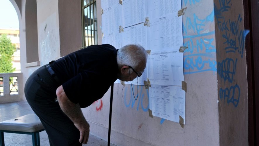 Un homme vérifie l'inscription de son nom sur les listes électorales dans un bureau de vote de Thessalonique, le 5 juillet 2015