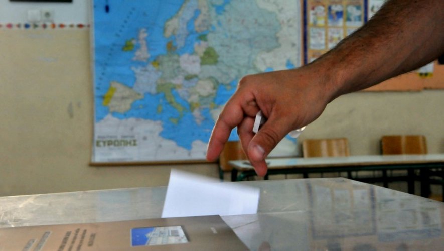 Un homme dépose son bulletin dans l'urne, dans une salle de classe organisée en bureau de vote, à  Thessalonique le 5 juillet 2015