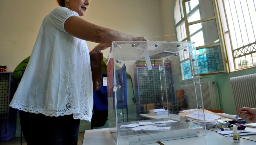 Une femme dépose son bulletin dans l'urne après avoir voté au référendum le 5 juillet 2015, à Thessalonique