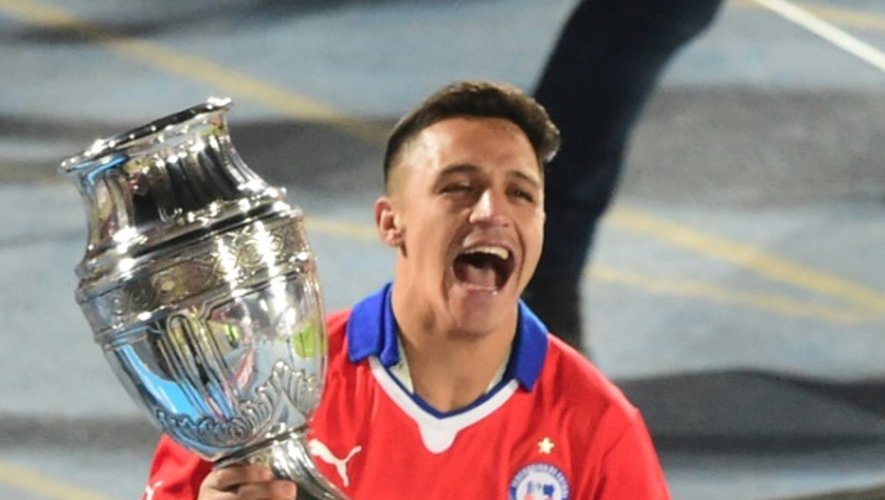 L'attaquant Alexis Sanchez célèbre, trophée en mains, la victoire du Chili en finale de la Copa America, le 4 juillet 2015 à Santigao