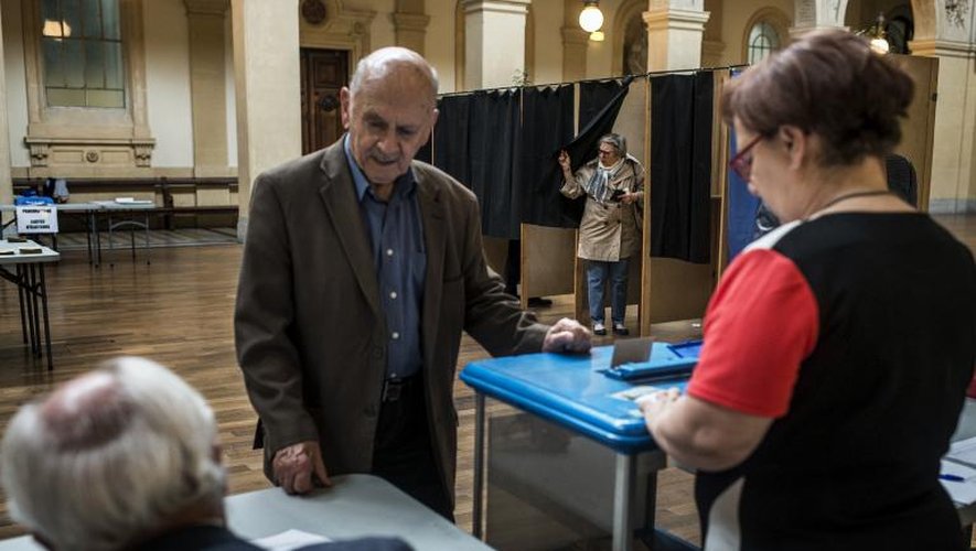Un électeur dépose son bulletin dans l'urne pour les européennes le 25 mai 2014 dans un bureau de vote à Lyon