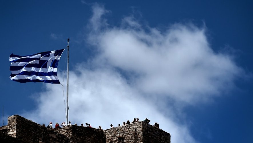 Un drapeau grec flotte au dessus de l'Acropole à Athènes