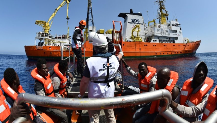 Des migrants s'apprêtent à monter à bord de  l'Aquarius, navire affrété par SOS Méditerranée et Médecins sans frontières (MSF) lors d'une opération de sauvetage le 24 mai 2016 en Méditerranée au large de la Libye