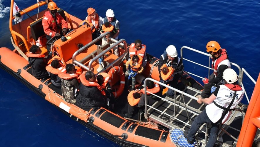 Des migrants s'apprêtent à monter à bord de  l'Aquarius, navire affrété par SOS Méditerranée et Médecins sans frontières (MSF) lors d'une opération de sauvetage le 24 mai 2016 en Méditerranée au large de la Libye