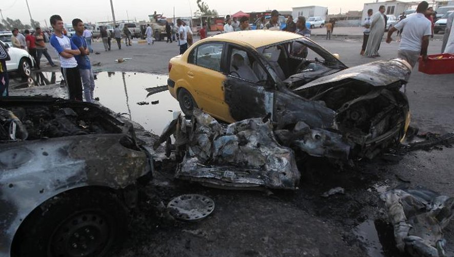 Des Irakiens sur le site d'un attentat à la voiture piégée le 27 mai 2013 à Bagdad