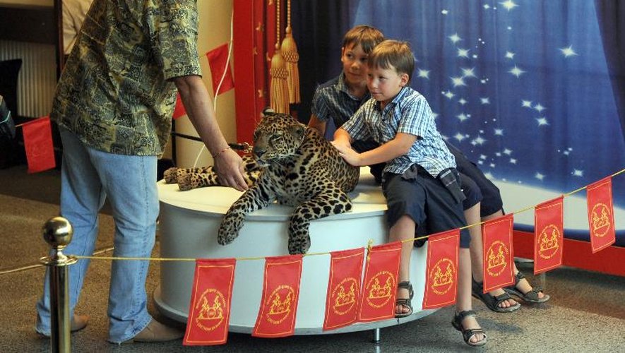 Des enfants posent pour une photo avec un léopard au cirque de Moscou le 24 juillet 2013