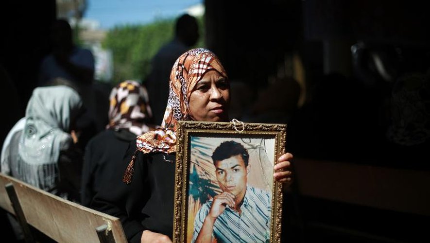 Une femme présente la photo d'un proche le 12 août 2013 alors qu'Israël a annoncé la libération prochaine de 26 détenus palestiniens