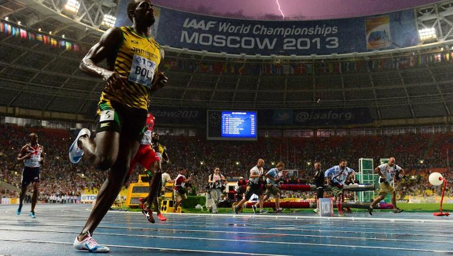 Le sprinter jamaïcain Usain Bolt remporte la finale du 100m, le 11 août 2013 lors des Mondiaux d'athlétisme, alors qu'un éclair illumine le ciel assombri de Moscou