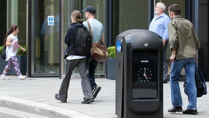 Des personnes passent près d'une poubelle "intelligente" capable de recueillir des données, le 12 août 2012 à Londres
