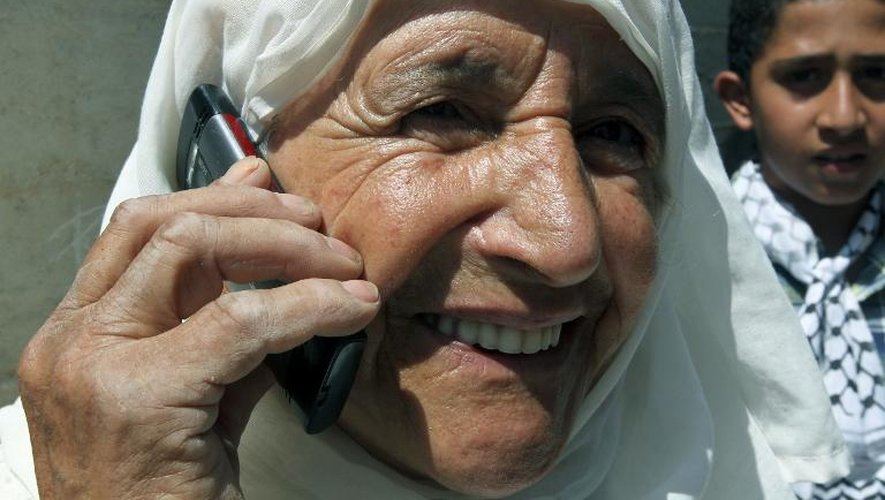 Une mère palestinienne annonce aux autres membres de sa familles la libération de son fils par Israël, le 12 août 2013 à Azmut dans la bande de Gaza