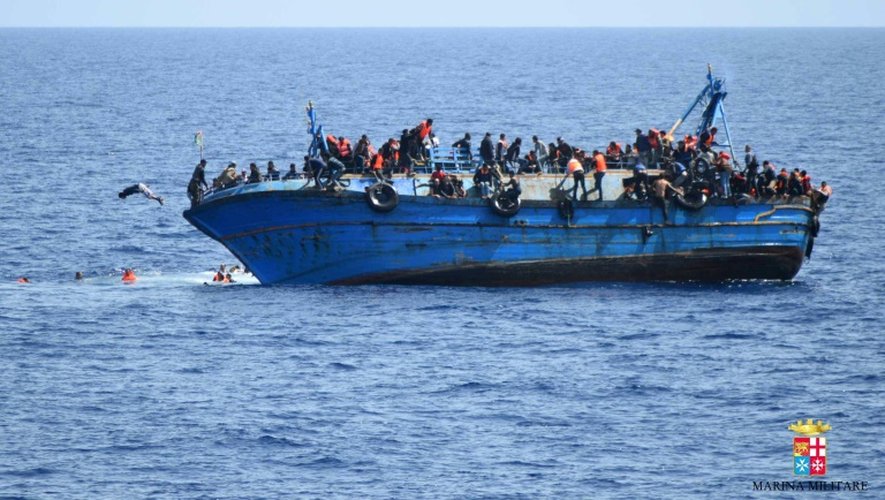 Photo fournie le 25 mai 2016 par la Marine italienne montrant un bateau de migrants sur le point de faire naufrage au large de la côte libyenne