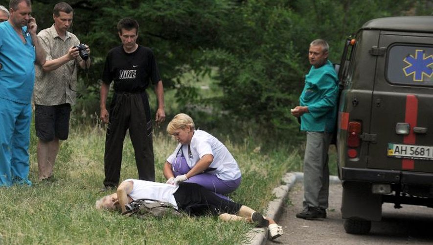 Un médecin examine une personne blessée lors des combats entre prorusses et armée ukrainienne à Slaviansk