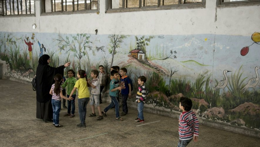 De jeunes Syriens jouent dans la cour de leur école à Alep en Syrie le 7 mai 2016
