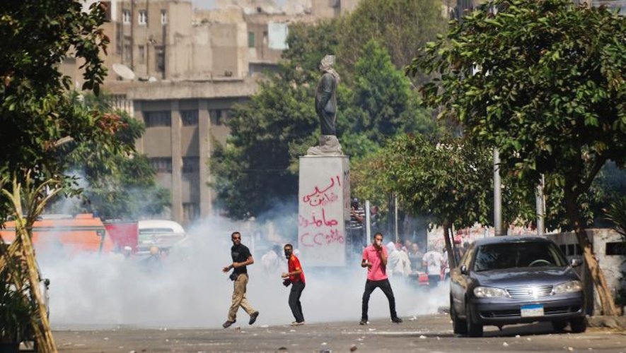 Des polciers égyptiens tirent des gaz lacrymogènes sur des partisans du président déchu Mohamed Morsi, au Caire le 13 août 2013