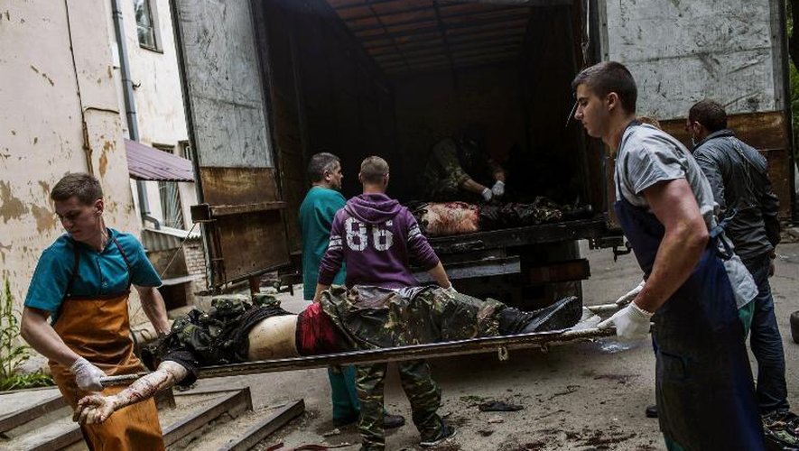 Des secours médicaux et des militants pro-Russes chargent des corps de combattants pro-Russes à Donetsk, le 27 mai 2014