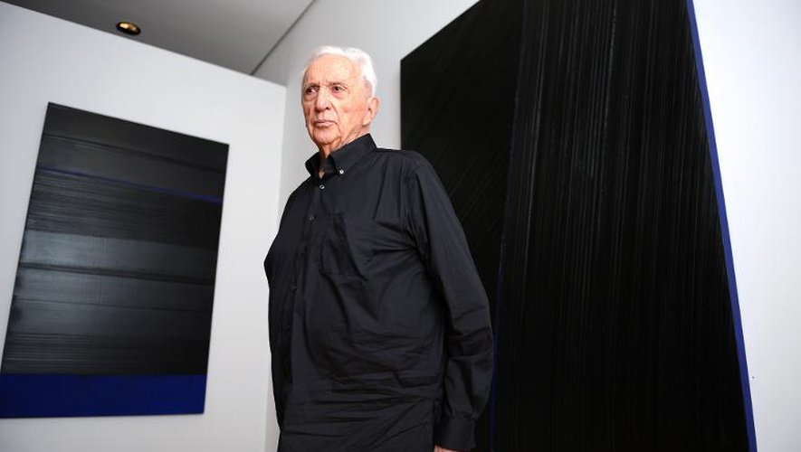 Le peintre français Pierre Soulages pose devant ses oeuvres lors de l'exposition "Soulages XXIe siècle" au musée des Beaux Arts de Lyon, le 11 octobre 2013