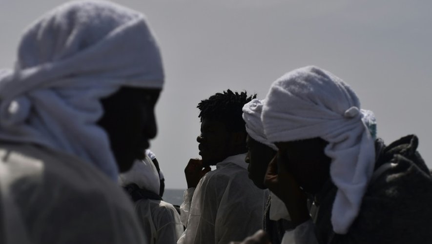 Des migrants regardent la Sardaigne depuis l'Aquarius le bateau qui les a pris en charge, au large des côtes libyennes le 26 mai 2016