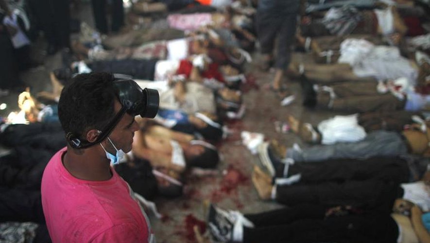 Un homme regarde les corps d'hommes tués lors de l'assaut policier au Caire, le 14 août 2013