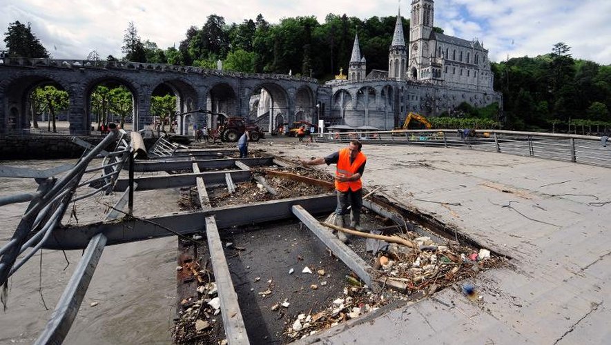 Des personnes s'activent pour nettoyer Lourdes après les inondations, le 20 juin 2013