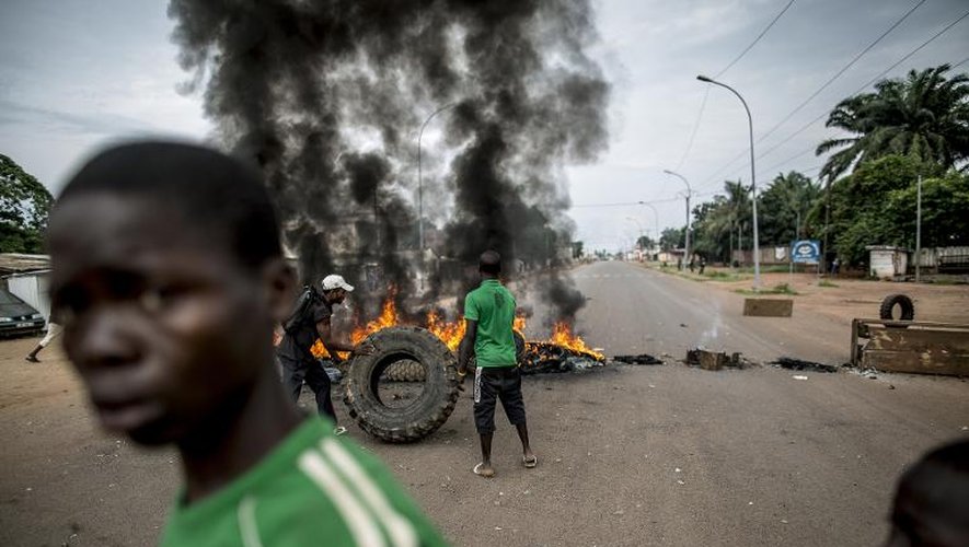 Des jeunes en colère, après l'attaque inédite d'une église ayant fait une quinzaine de morts, érigent une barricade avec des pneus incendiés à Bangui le 29 mai 2014