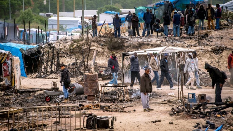 Des migrants s'activent pour remettre de l'ordre dans la "Jungle" de Calais le 27 mai 2016 au lendemain d'une importante rixe qui a fait 40 blesséz