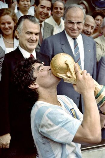 Le capitaine de l'équipe d'Argentine Diego Maradona embrasse la Coupe du monde après la victoire de son équipe en finale contre l'Allemagne, le 29 juin 1986 à Mexico