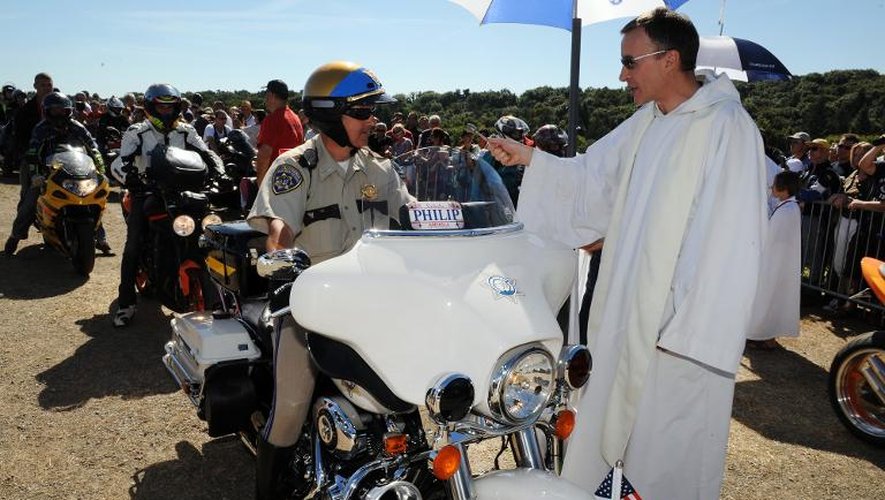 Un prêtre bénit un motard à Porcaro (ouest), le 15 août 2013