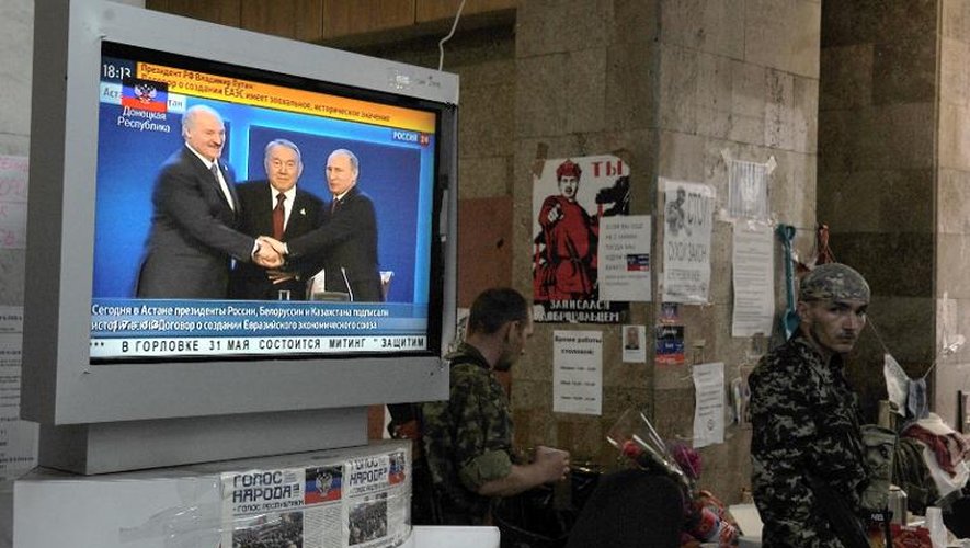 Des combattants pro-Russes regardent la télévision à Donetsk le 29 mai 2014