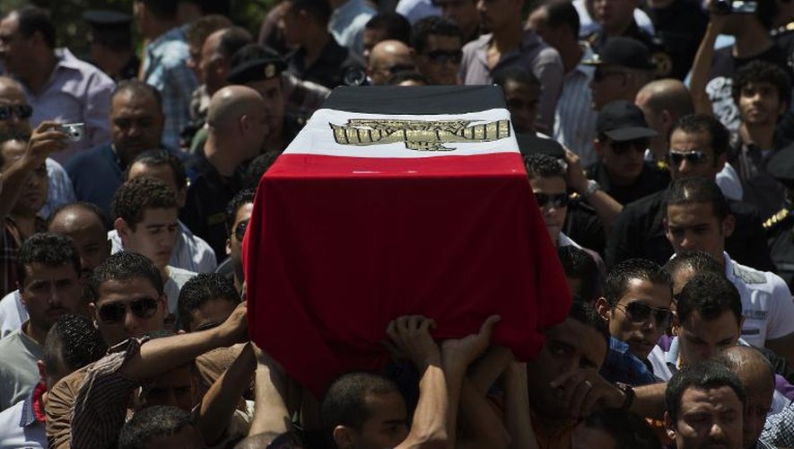 Des Egyptiens portent le cerceuil d'un des policiers tués lors des affrontements avec les pro-Morsi, le 15 août 2013 au Caire