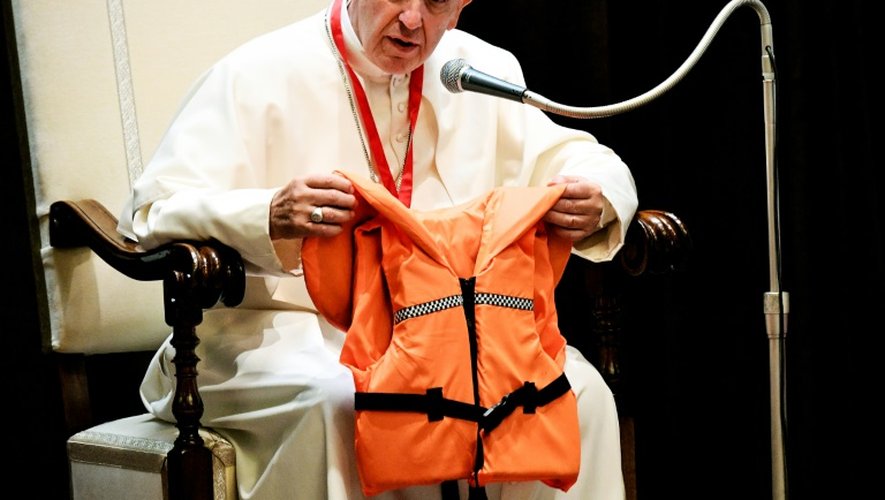 Le pape François montre lors d'une réunion avec des jeunes, le 28 mai 2016 au Vatican, le gilet de sauvetage d'un jeune qui s'est noyé en Méditerranée en essayant de rejoindre l'Europe