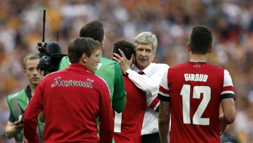 L'entraîneur d'Arsenal Arsène Wenger félicite ses joueurs pour leur victoire en finale de Coupe d'Angleterre, le 17 mai 2014 contre Hull à Wembley