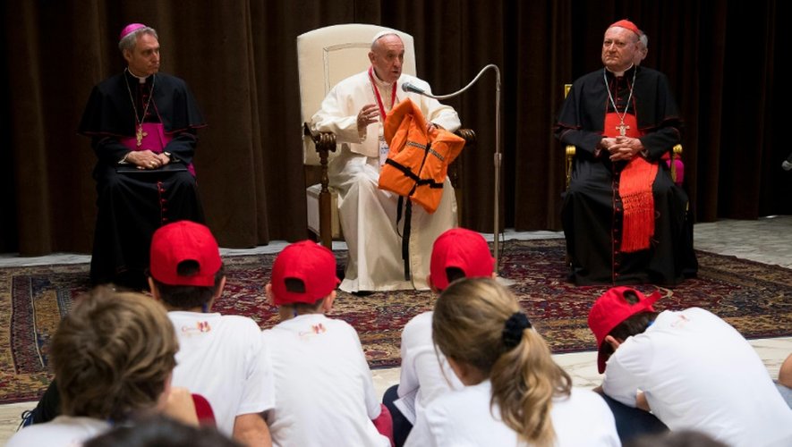 Le pape François lors d'une réunion avec des jeunes au Vatican, le 28 mai 2016 montre le gilet de sauvetage d'un jeune qui s'est noyé en Méditerranée en tentant de rejoindre l'Europe