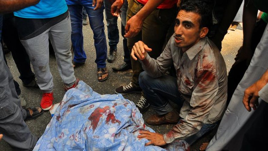 Un manifestant pro-Morsi tué est recouvert d'un drap le 16 août 2013 dans la banlieue du Caire