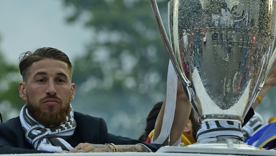 Le défenseur du Real Madrid Sergio Ramos à côté de la Coupe de la Ligue des champions dans le bus décapotable sillonnant les rues de Madrid, le 29 mai 2016
